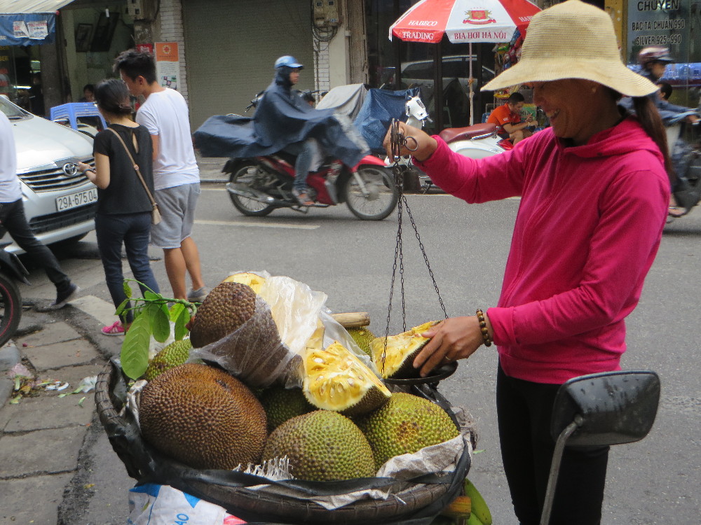 Vietnamesische Obsthändlerin mit einer Jackfruit